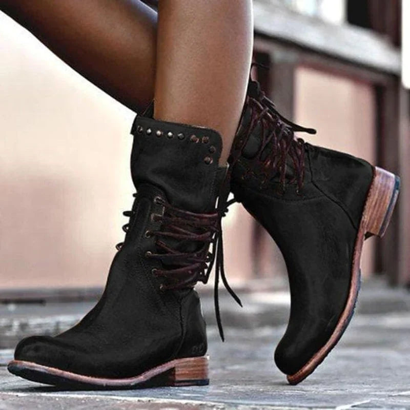 Close-up of grey lace-up ankle boots showing structured leather-look finish and stacked heel