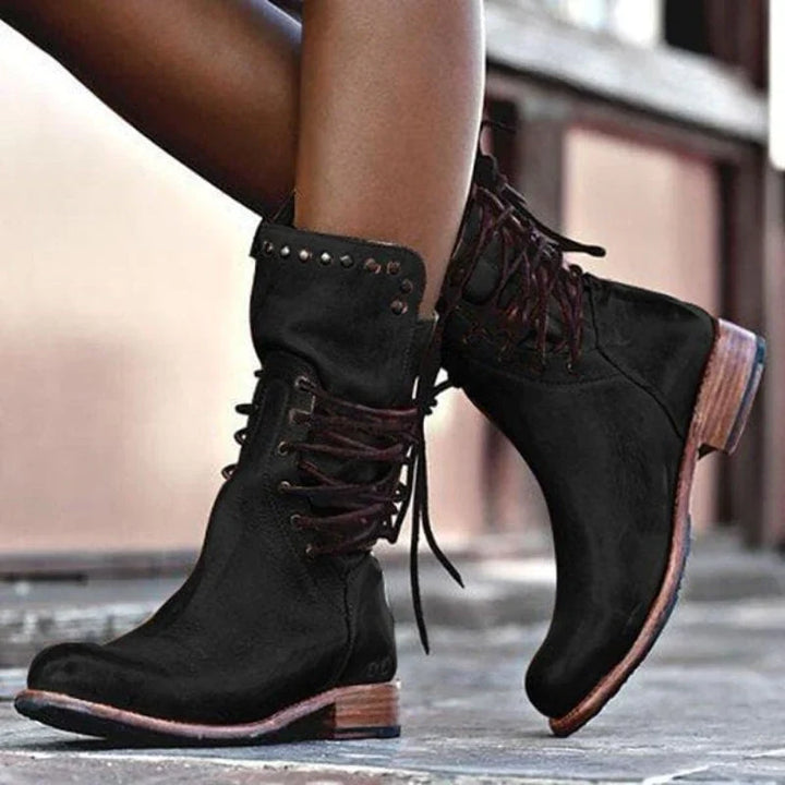 Close-up of grey lace-up ankle boots showing structured leather-look finish and stacked heel