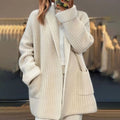 Close-up view of oversized knit cardigan showing ribbed texture and front patch pockets