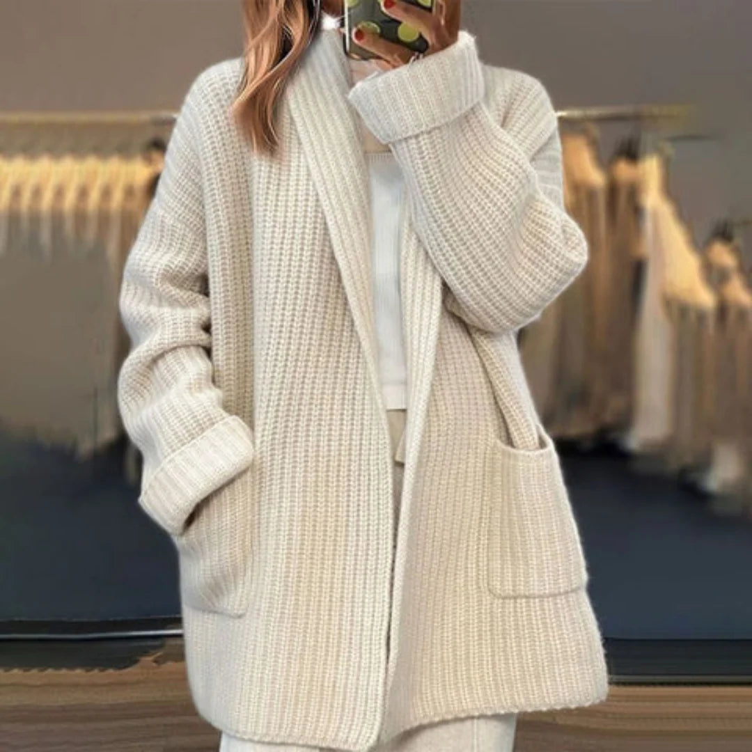 Close-up view of oversized knit cardigan showing ribbed texture and front patch pockets
