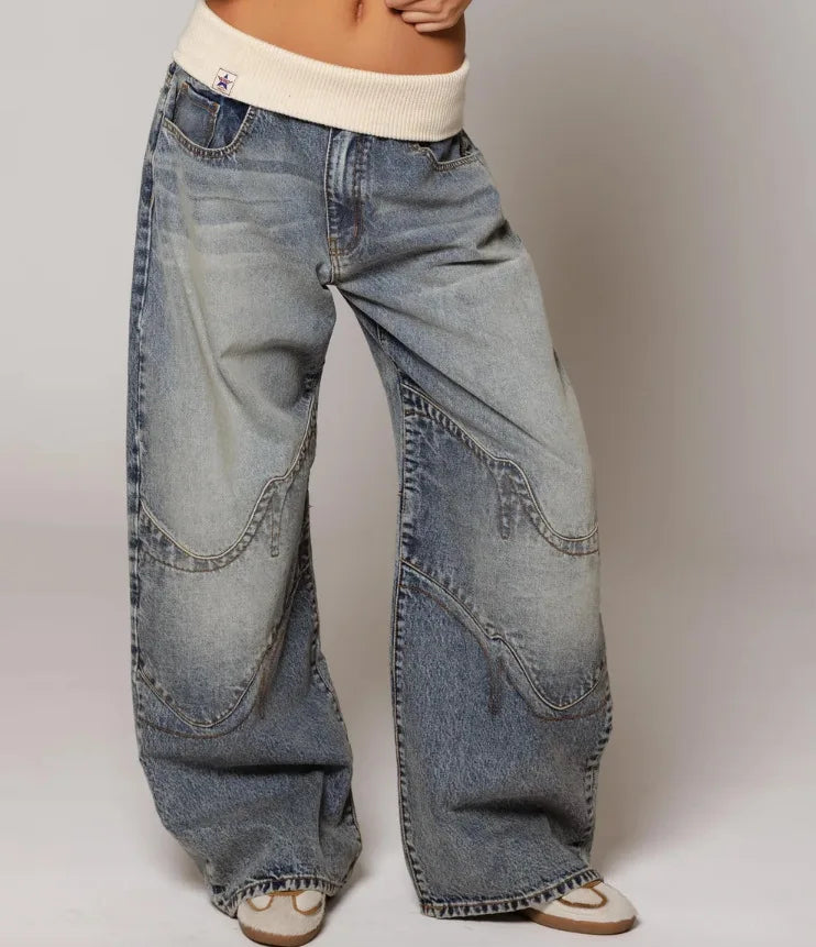 Detail shot of vintage light wash denim fabric showing structured drape and authentic faded finish
