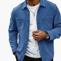 Men's corduroy shirt jacket in blue with button closure and dual chest pockets worn casually