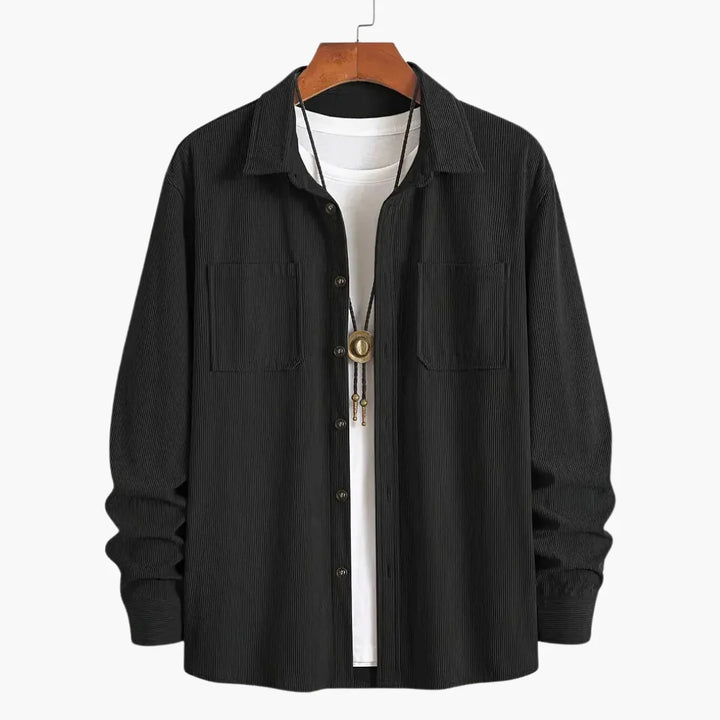 Men's blue corduroy shirt jacket worn open over white tee for casual layering
