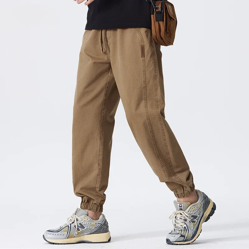 Men's relaxed joggers in khaki with elasticated ankle cuffs and drawstring waist worn casually