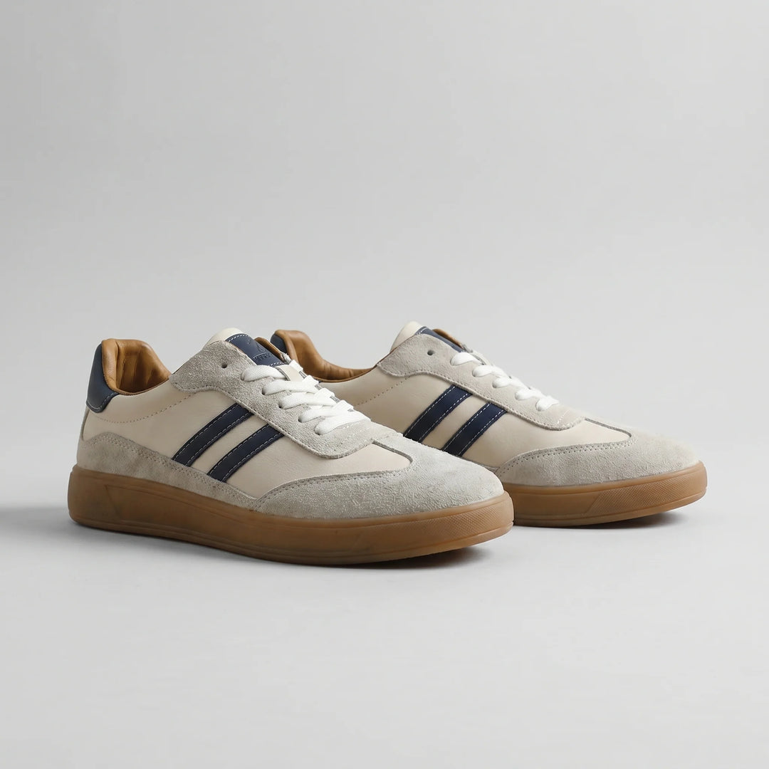 Side view of men's retro trainers showing navy stripe detailing and gum rubber sole