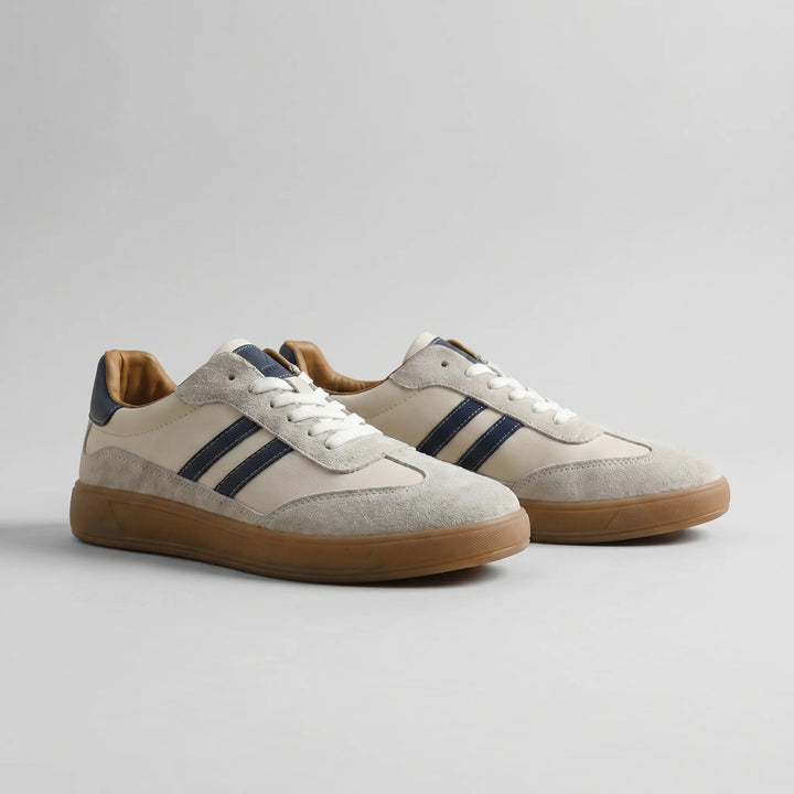 Side view of men's retro trainers showing navy stripe detailing and gum rubber sole