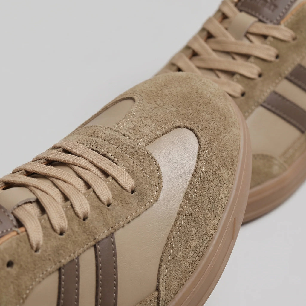 Men's retro trainers side profile with gum sole and navy accents