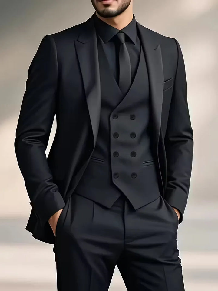 Man wearing a black three-piece suit with double-breasted waistcoat and matching blazer and trousers