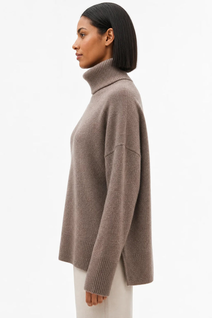 Side angle showing the relaxed drape and ribbed detailing of the merino turtleneck jumper