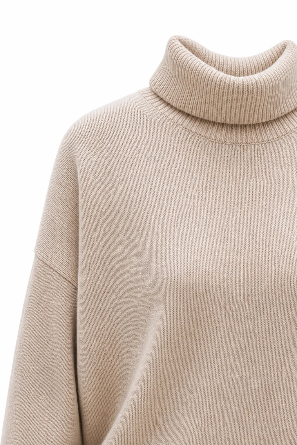 Woman wearing the oversized turtleneck jumper layered over a shirt for contemporary winter styling