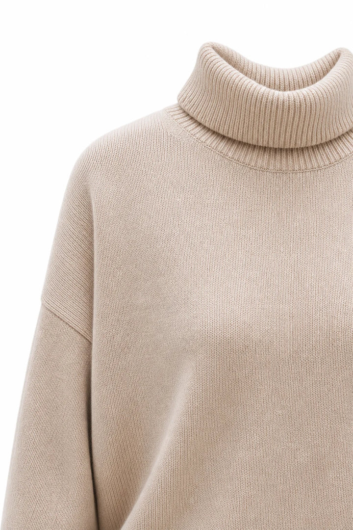 Woman wearing the oversized turtleneck jumper layered over a shirt for contemporary winter styling