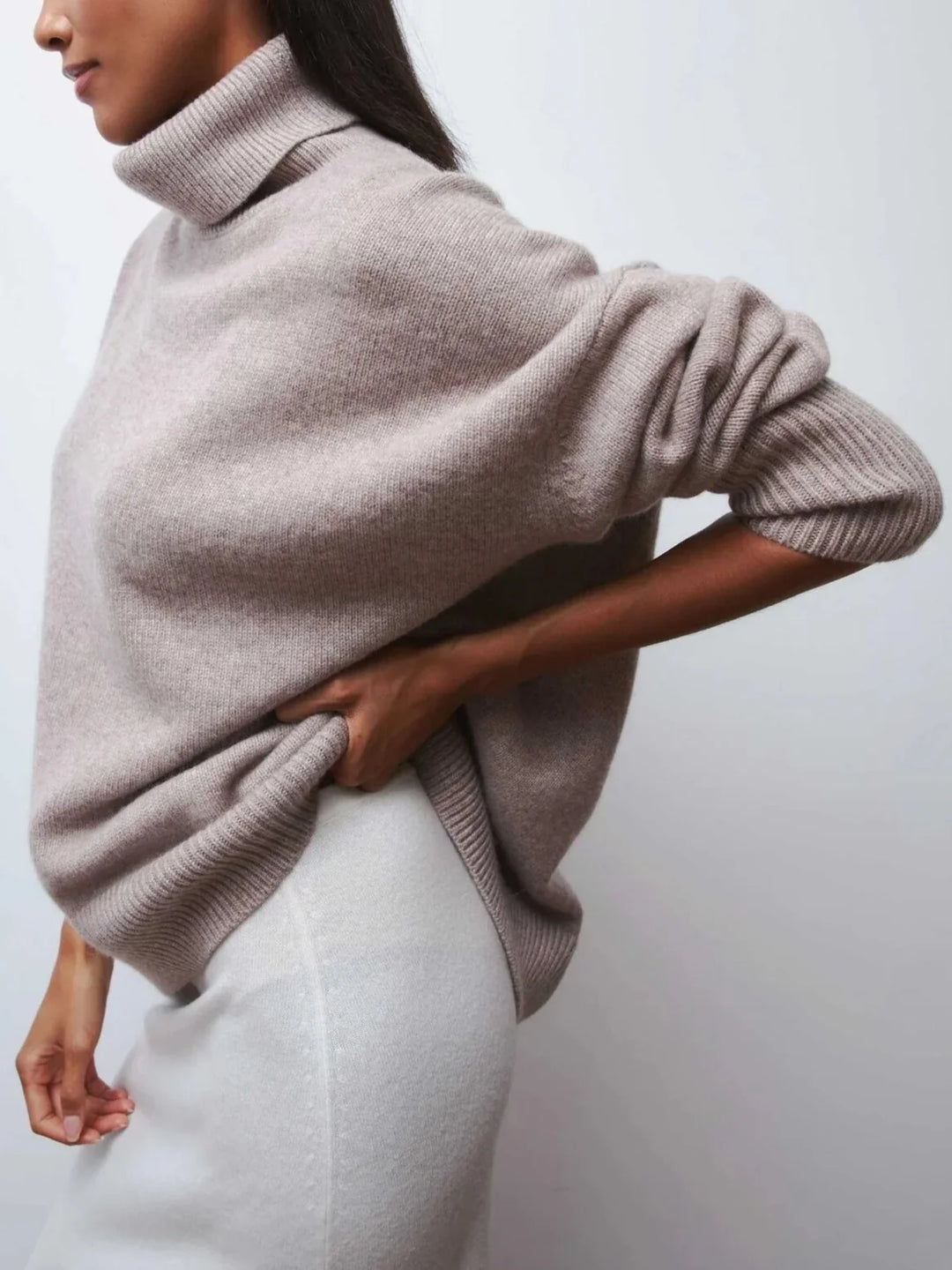 Close-up of the roll neck collar and soft knit fabric on the oversized turtleneck jumper