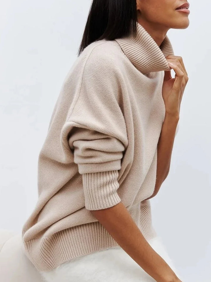 Close-up view of the ribbed hem and relaxed silhouette on the women's turtleneck jumper