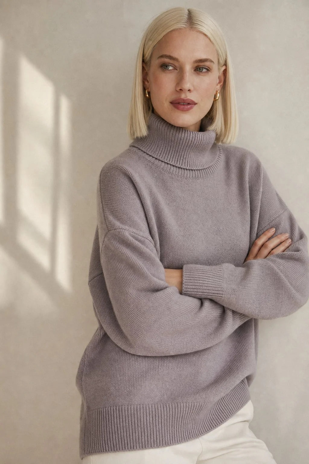 Side profile of the women's oversized turtleneck jumper with dropped shoulders and generous roll neck