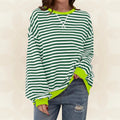 Woman wearing green and white striped oversized sweatshirt with neon yellow contrast trim and relaxed fit