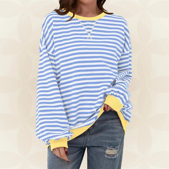 Detail of contrast trim crew neckline and ribbed hem on oversized striped sweatshirt
