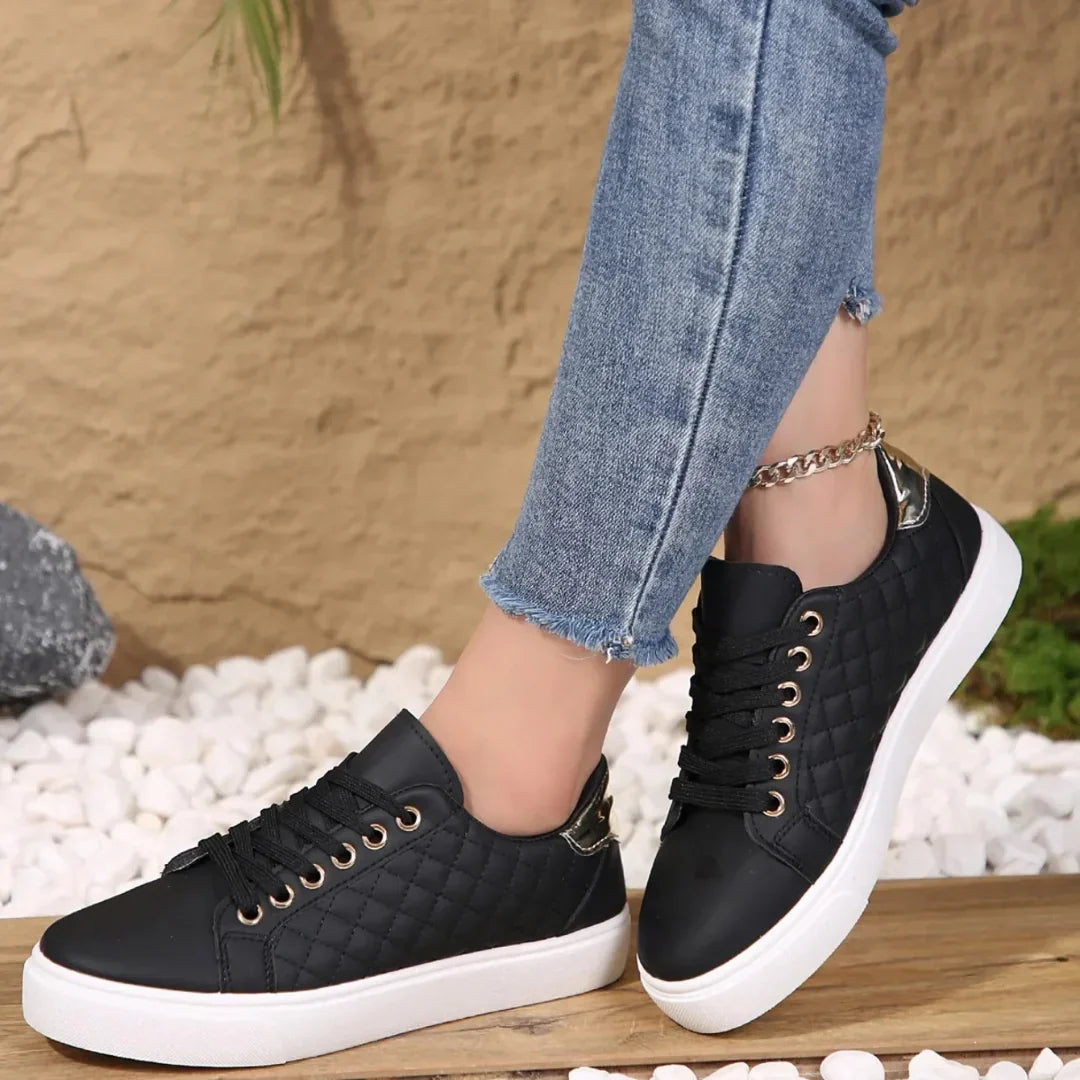 Women's quilted trainers with lace-up closure and white platform sole worn with cropped jeans