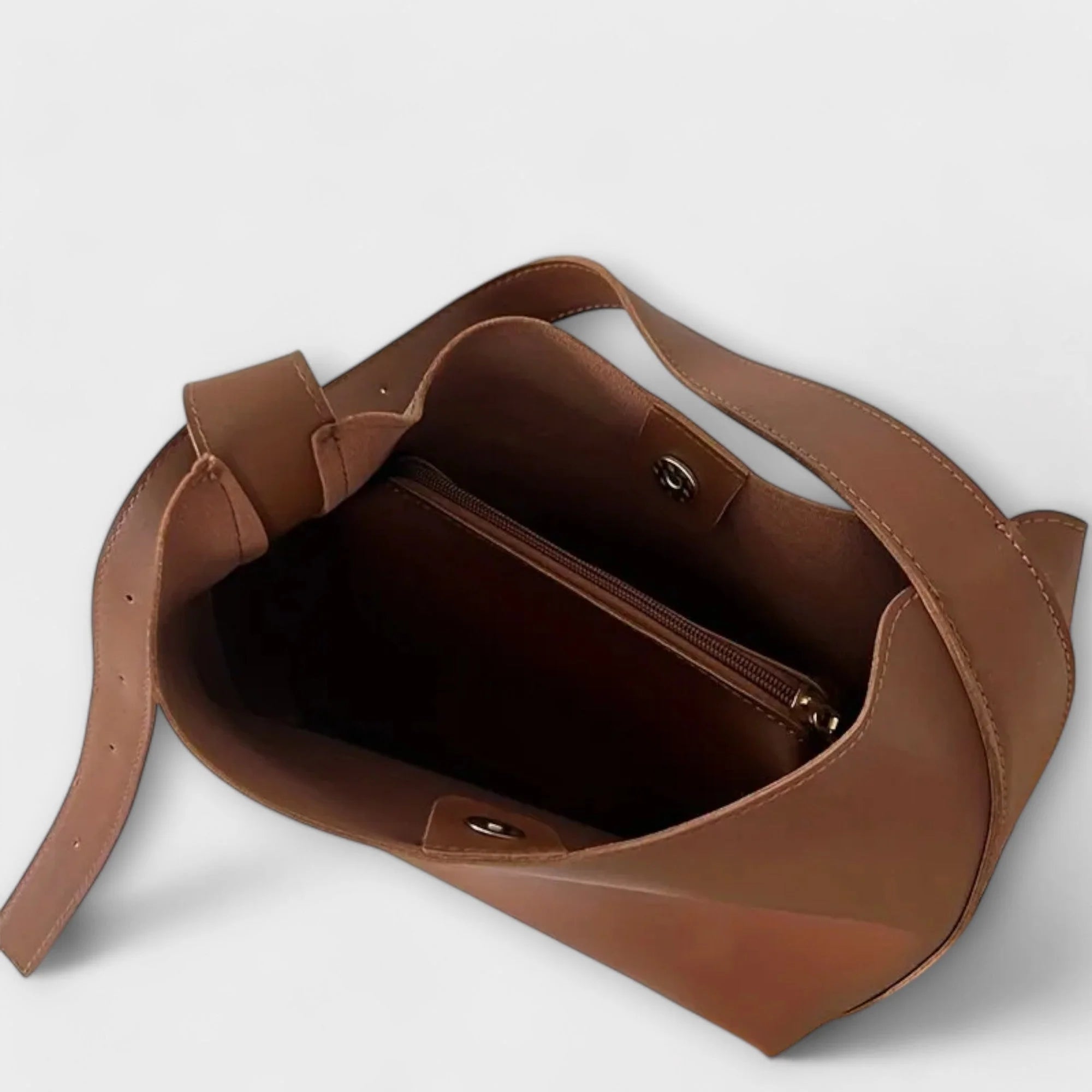 Side view of slouchy shoulder bag with structured base and smooth finish