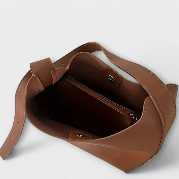 Side view of slouchy shoulder bag with structured base and smooth finish