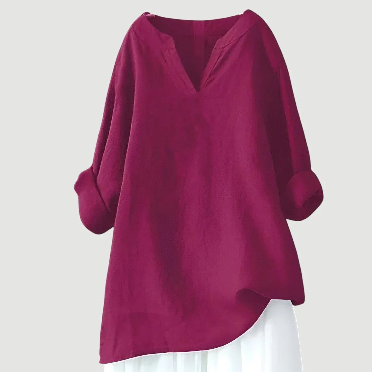 Side view of relaxed-fit tunic displaying curved hem and flowing drape with roll-up sleeves