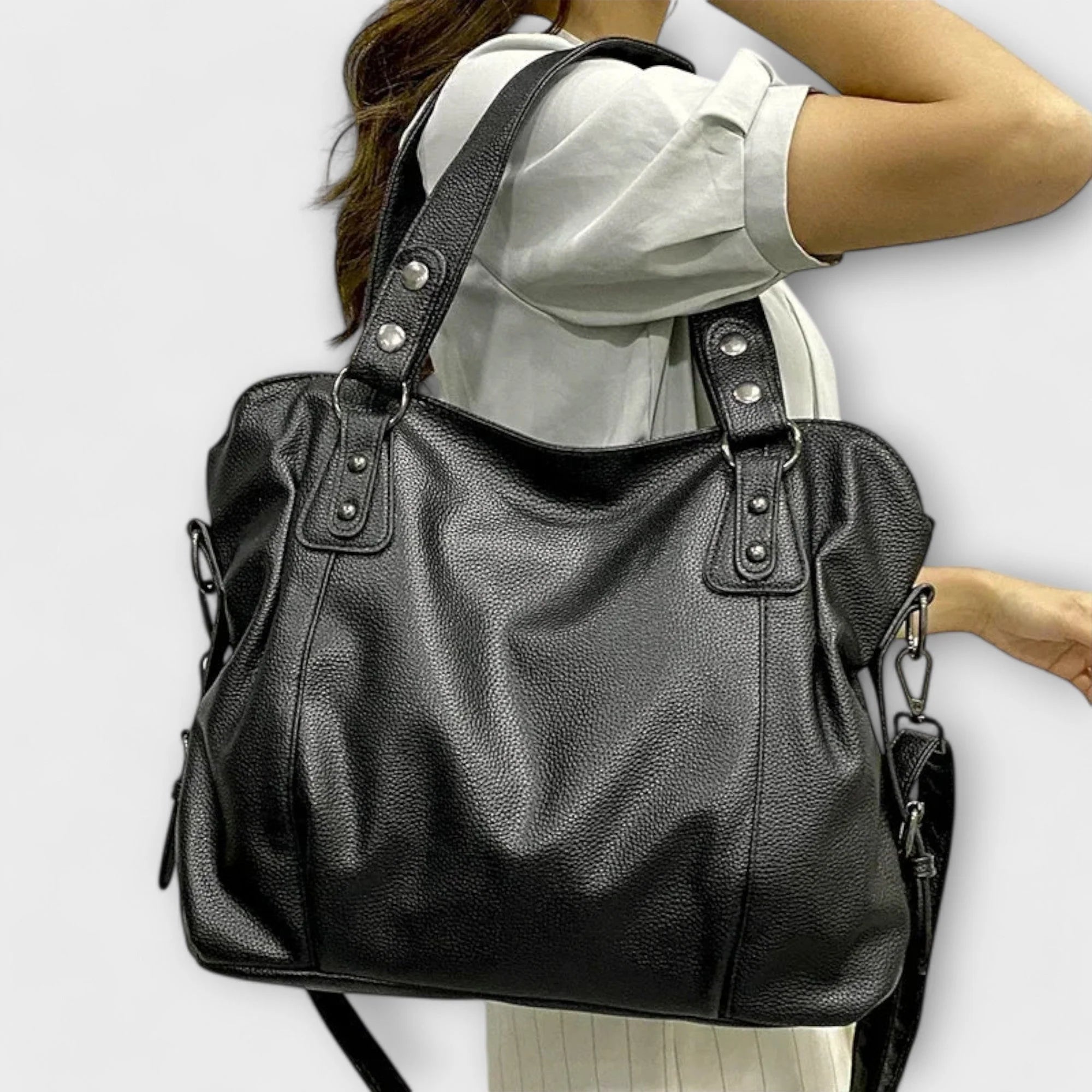 Side view of slouchy hobo bag showing zip pocket detail and metal hardware accents