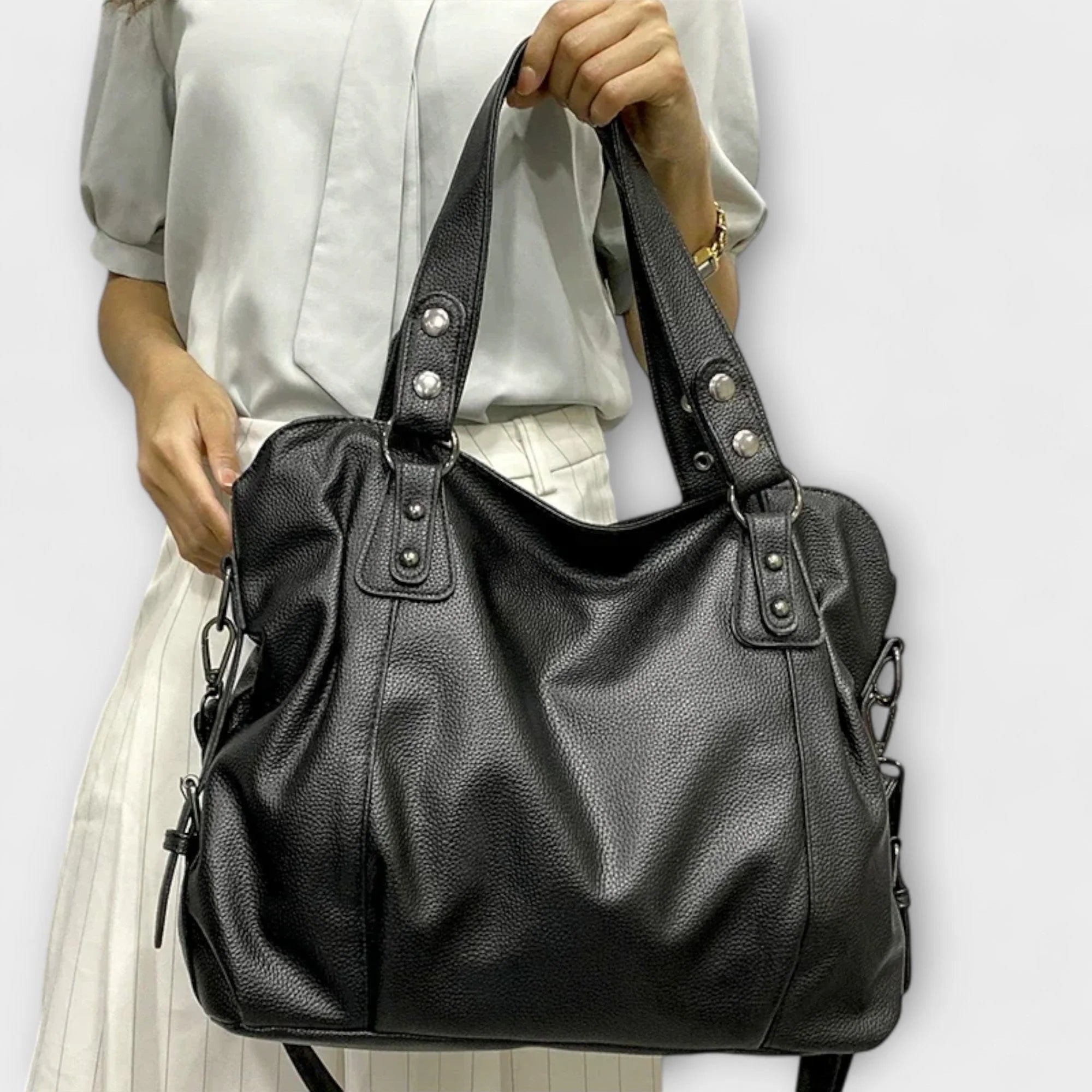 Close-up of studded top handle attachment with metal grommets on hobo shoulder bag