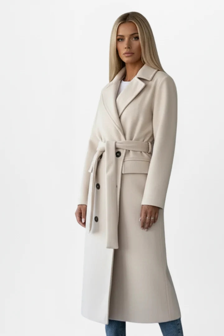 Side profile of women's belted trench coat displaying structured silhouette and patch pockets