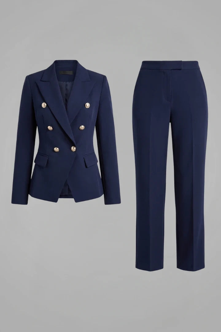 Women's navy double-breasted blazer suit set with structured shoulders and matching straight-leg trousers on grey background