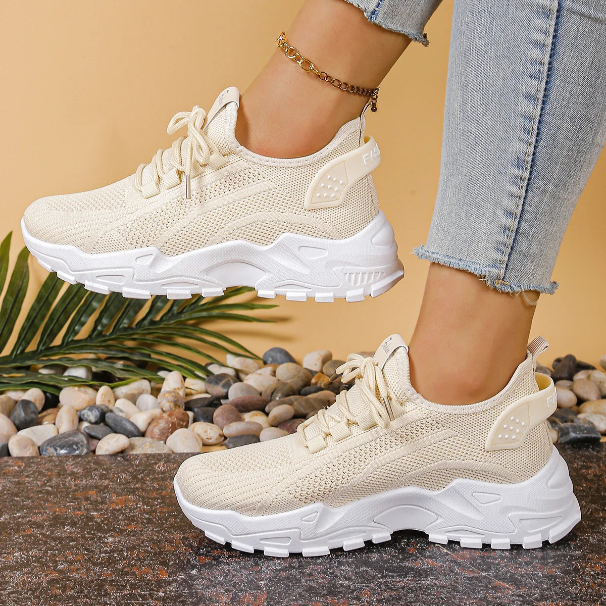 Side view of women's white mesh trainers with textured outsole and cushioned midsole