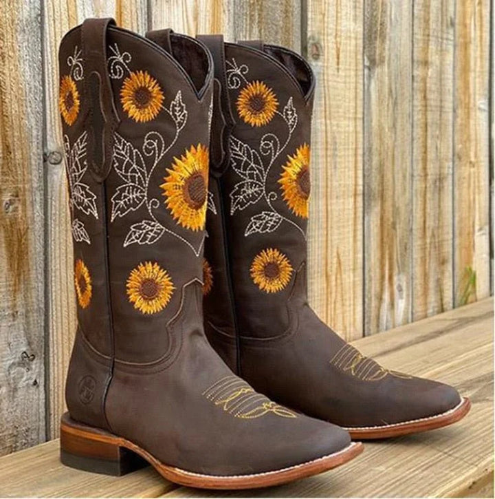 Detail shot of sunflower embroidery and Western stitching on women's mid-calf cowboy boots