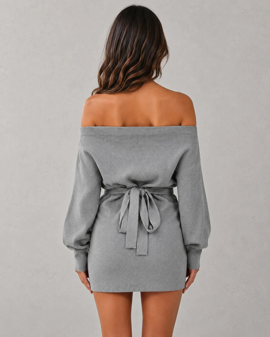 Side angle of tie waist detail on off-shoulder knit mini dress