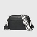 Women's crossbody bag in textured black finish with geometric patterned adjustable shoulder strap and zip closure