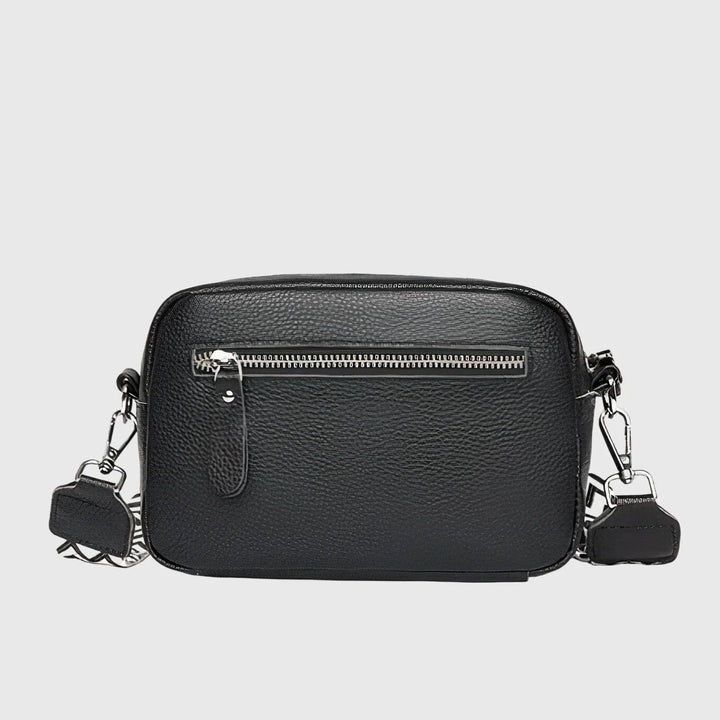Close-up view of women's crossbody bag showing pebbled texture and front slip pocket detail