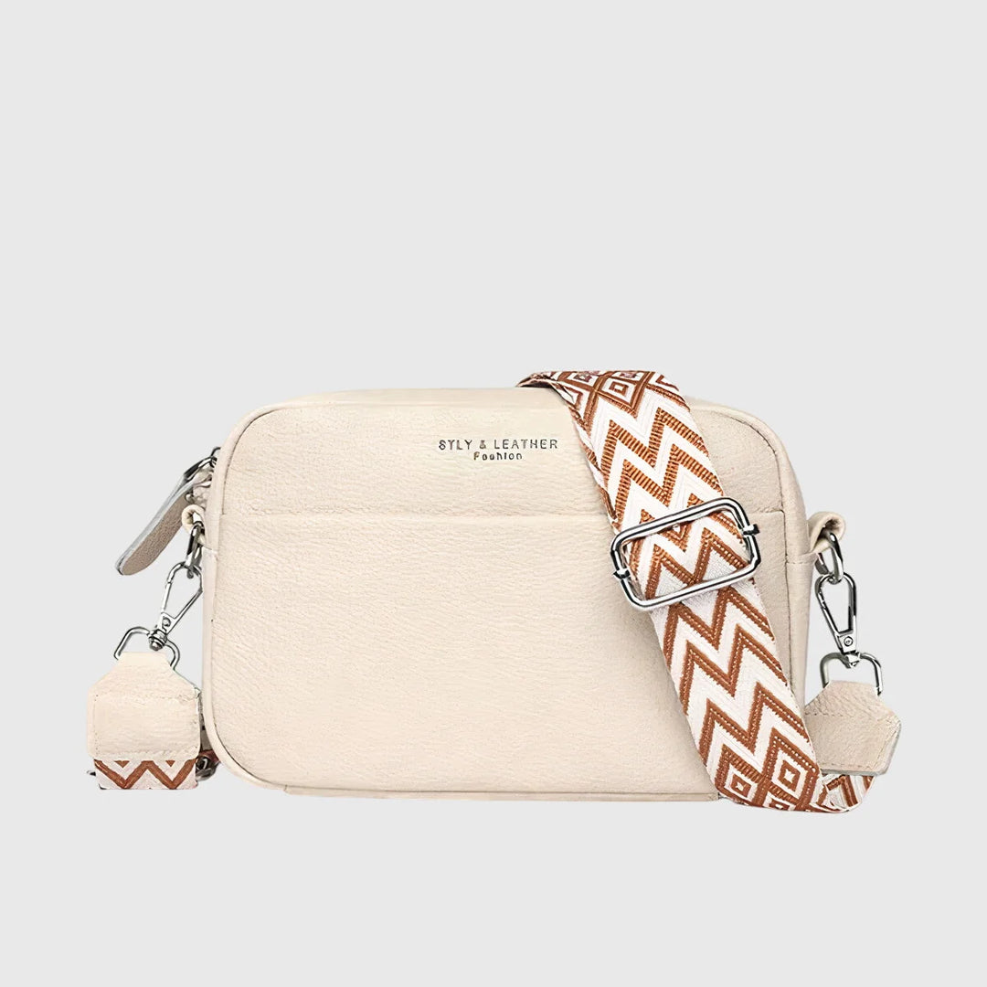 Side angle of compact crossbody bag displaying curved silhouette and adjustable woven strap