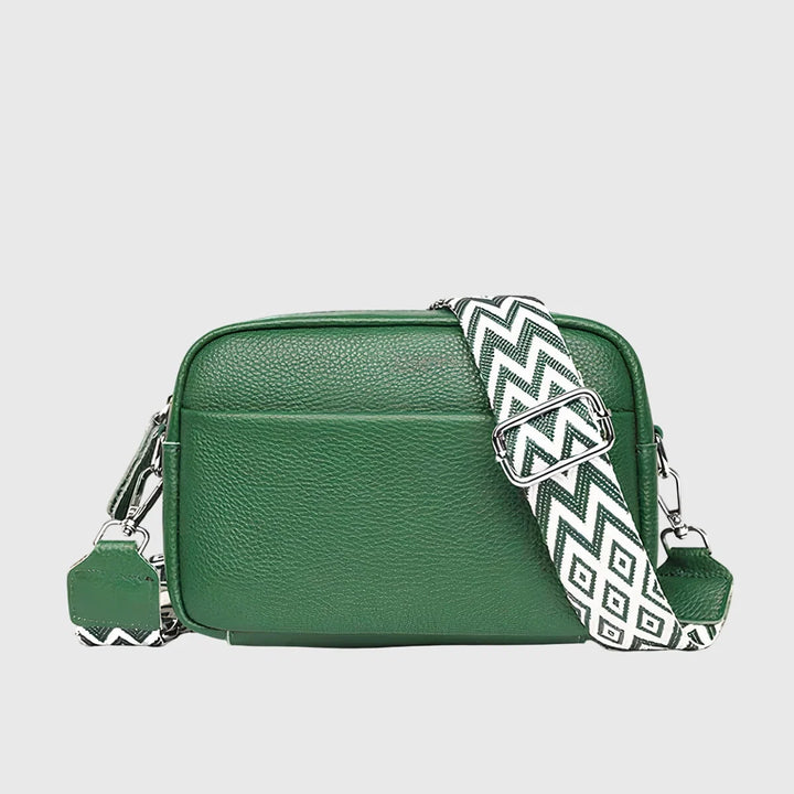 Detail shot of crossbody bag zip closure and front pocket with embossed branding