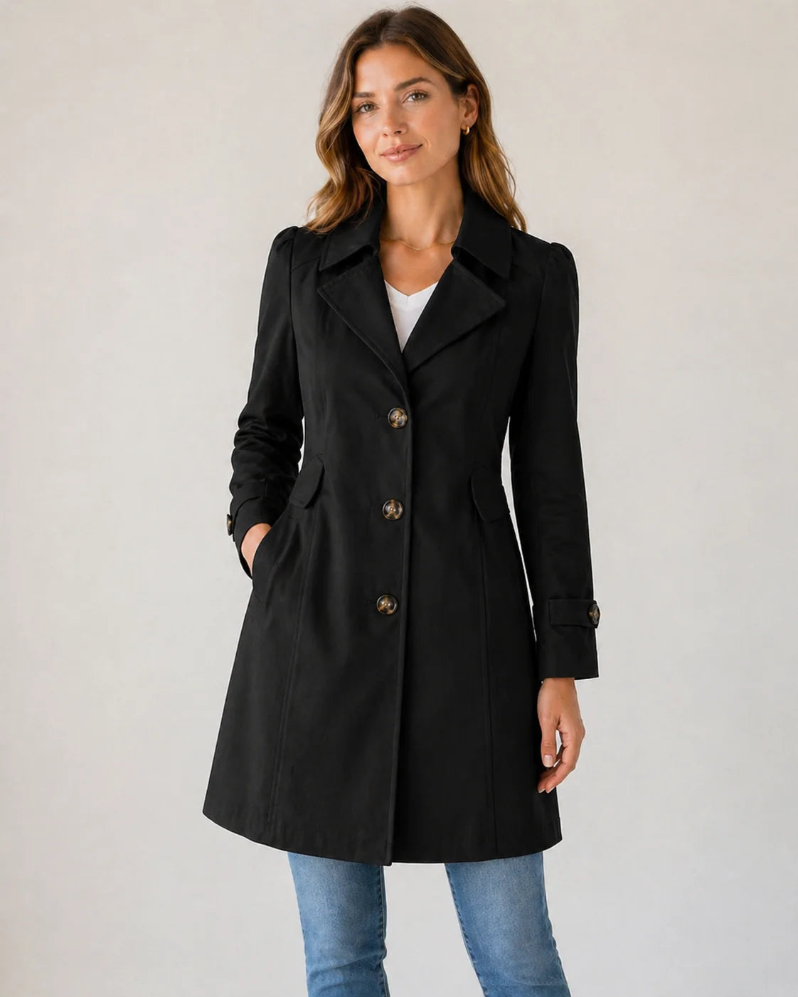 Full-length view of beige women's trench coat with classic tailoring details
