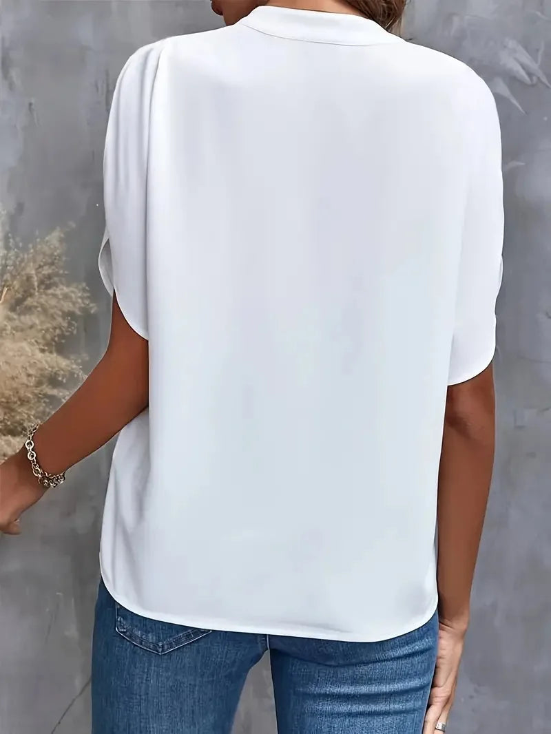 Close-up of V-neckline and concealed placket detail on women's blouse with smooth fabric