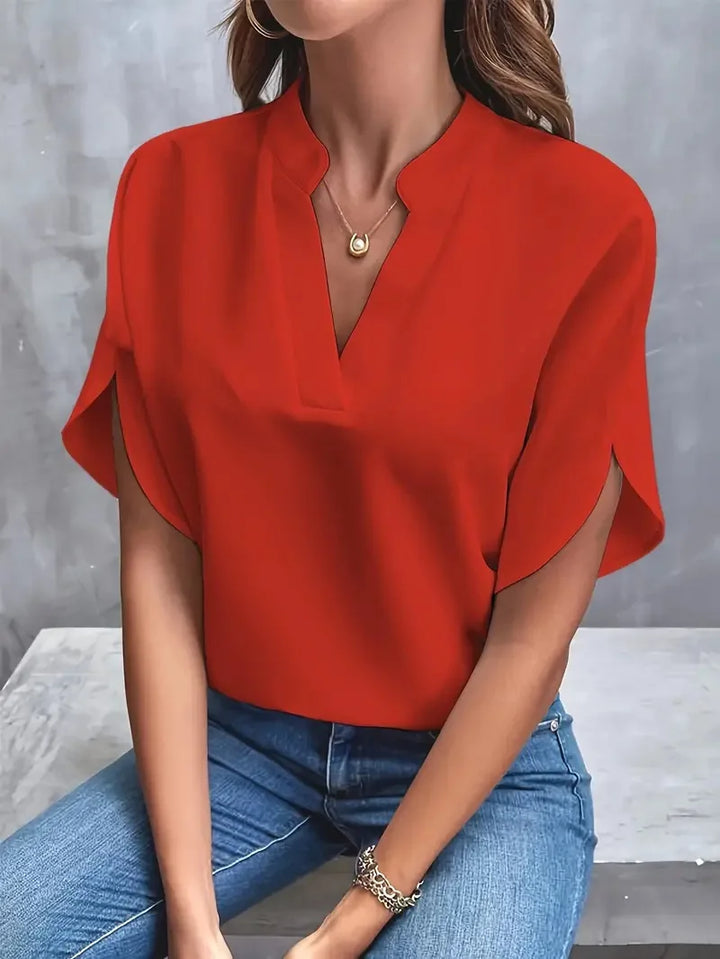 Detail of rolled sleeve hem on women's V-neck blouse with smooth drape