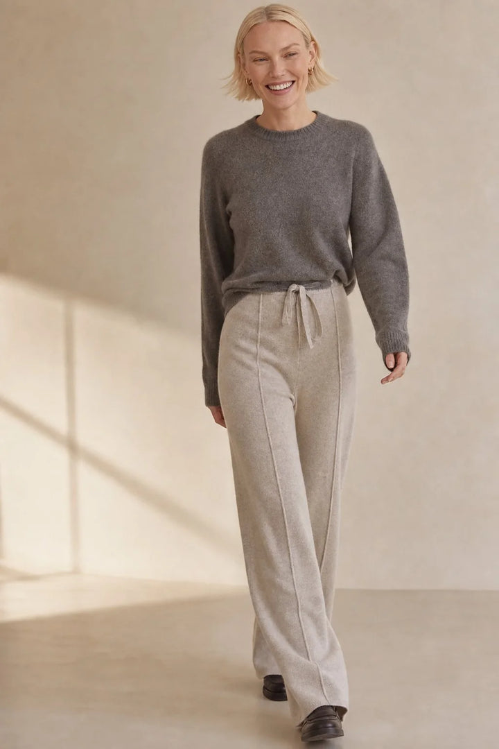 Close-up view of high waist wool trousers showing adjustable drawstring and pintuck detail