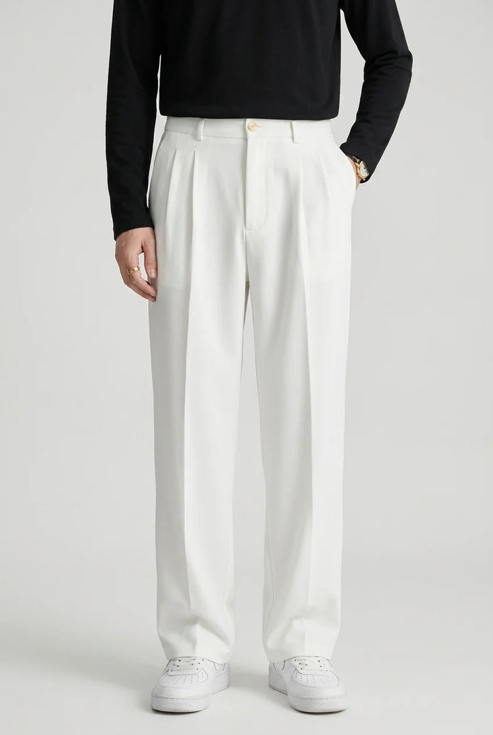 Detail of high waist pleated trousers showing tailored construction and fabric drape