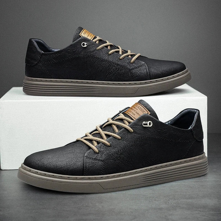 Side view of men's beige trainers showing contrast navy heel tab and tonal stitching