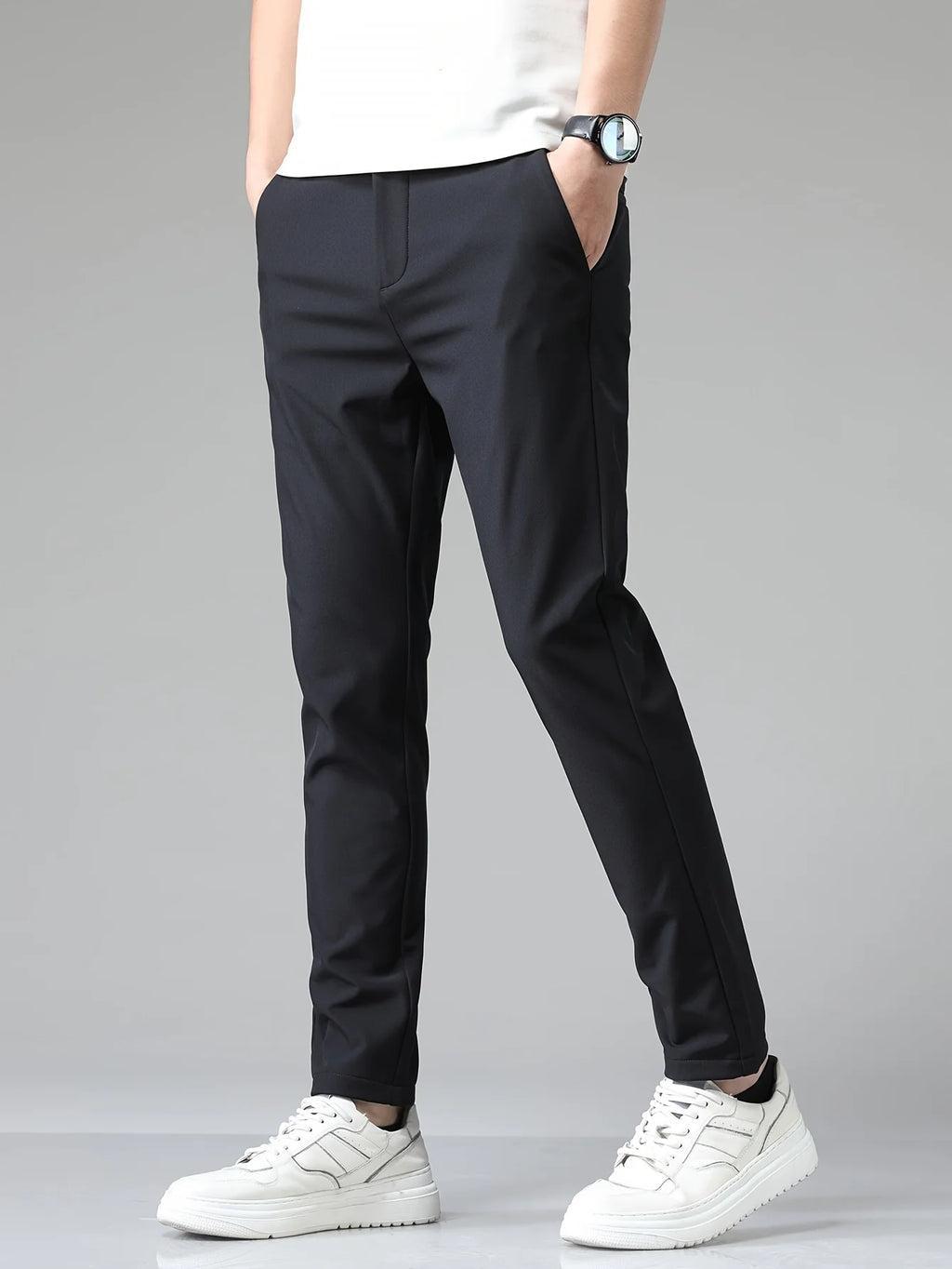 Men's slim fit trousers in navy with straight leg cut and mid-rise waist worn with white trainers