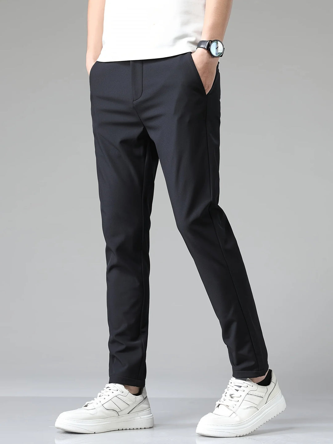 Men's slim fit trousers in navy with straight leg cut and mid-rise waist worn with white trainers