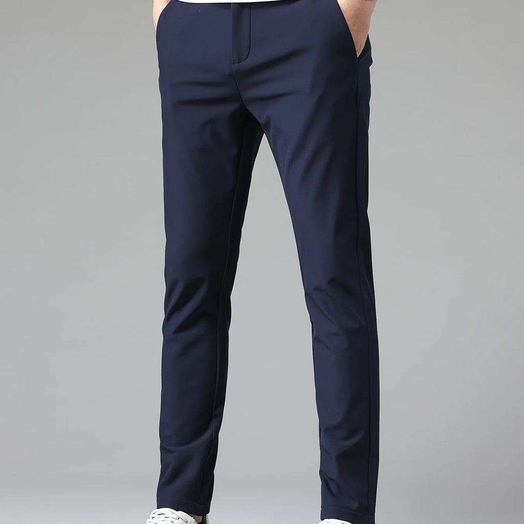 Men's navy trousers styled for business-casual wear with white t-shirt and trainers
