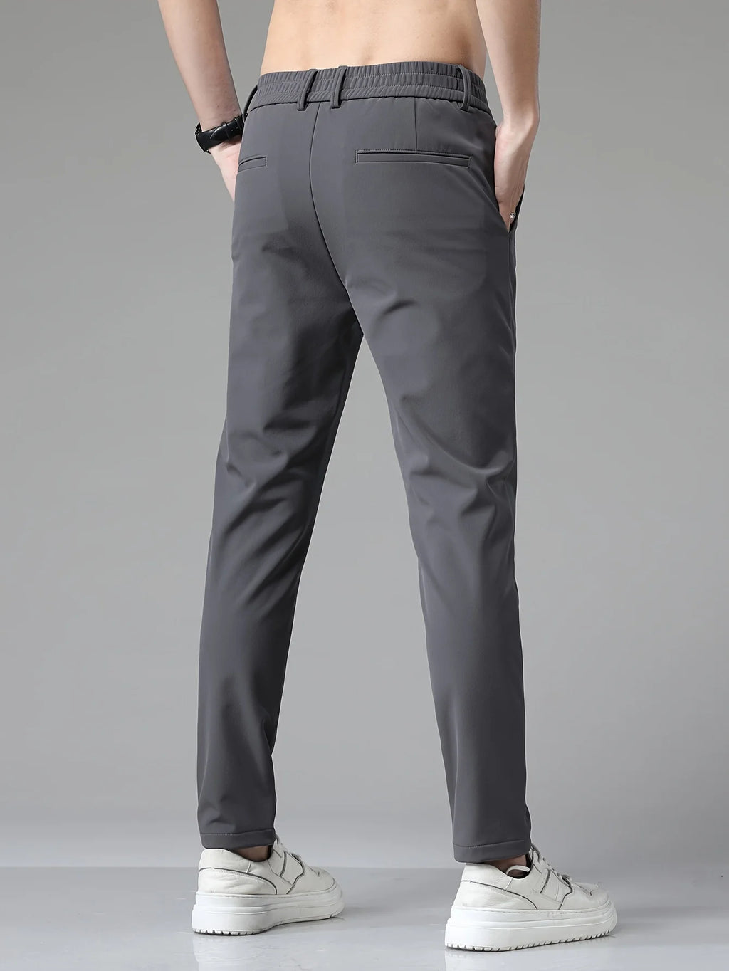 Detail shot of men's trousers showing mid-rise waist and front slant pocket construction