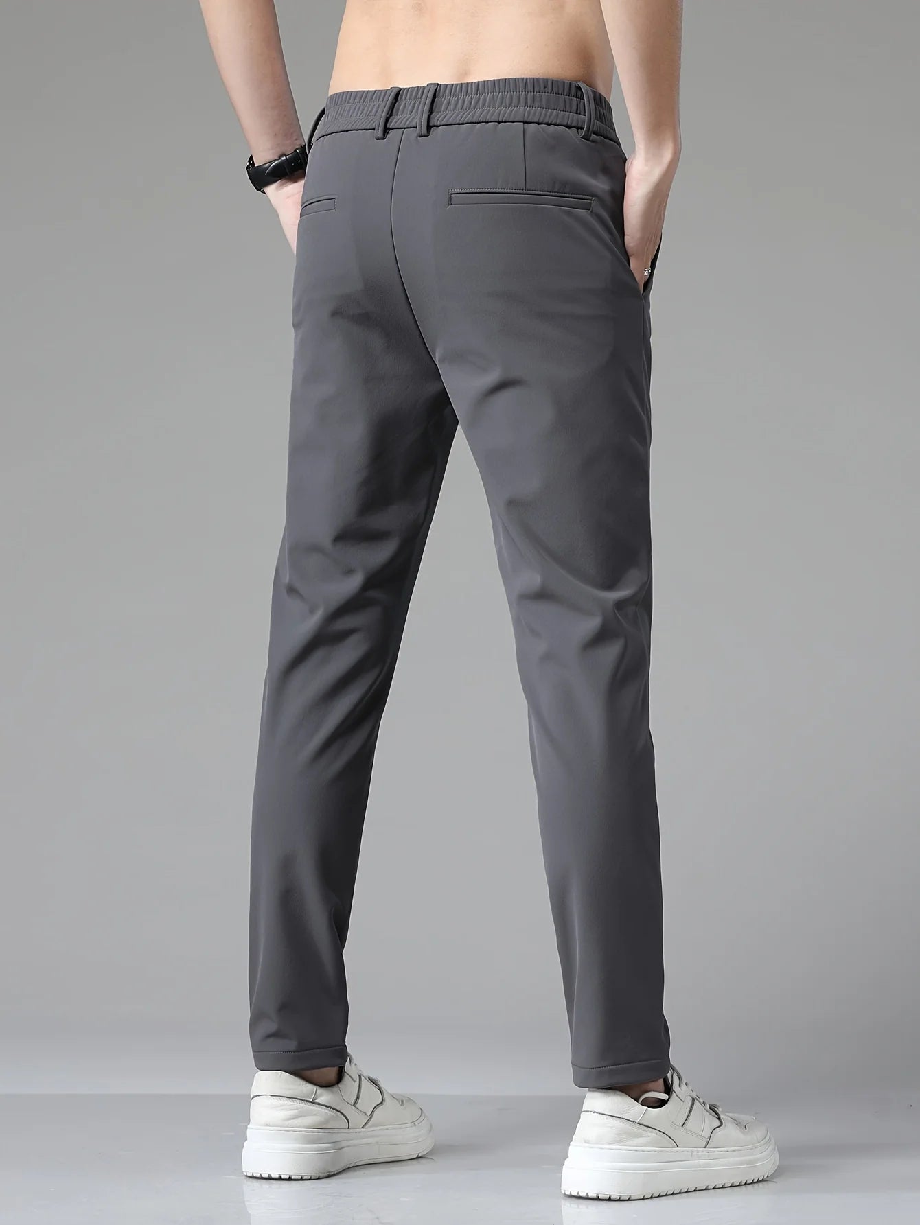 Detail shot of men's trousers showing mid-rise waist and front slant pocket construction