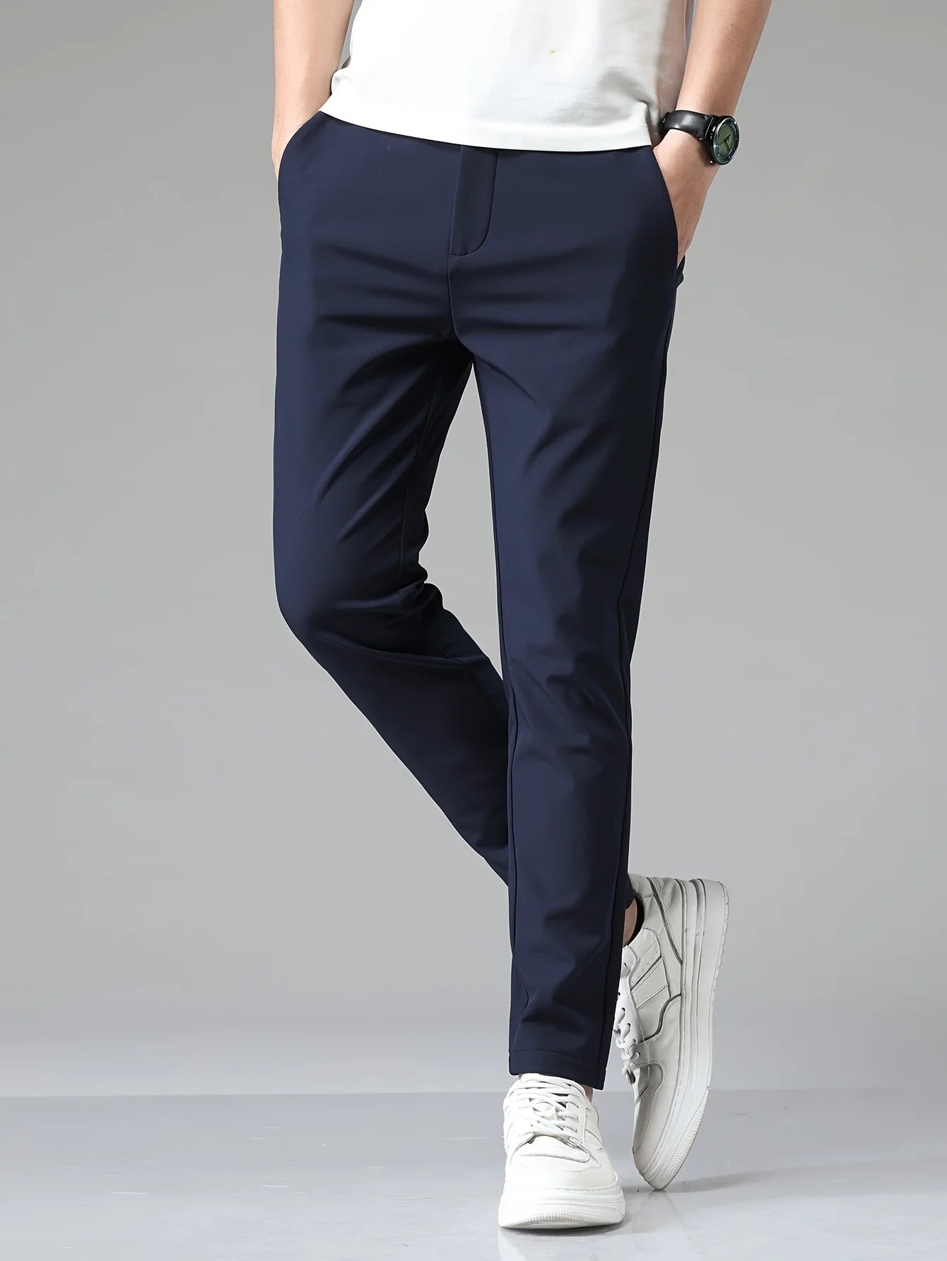 Men's slim fit trousers styled with white t-shirt demonstrating versatile business-casual look