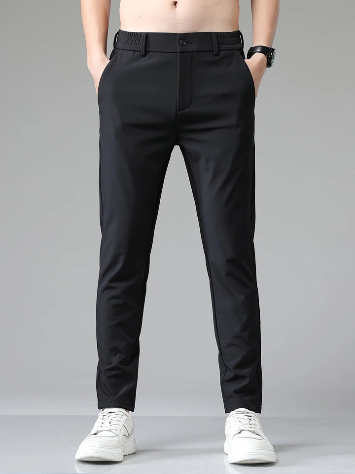 Men's navy trousers paired with casual trainers for smart-casual styling versatility