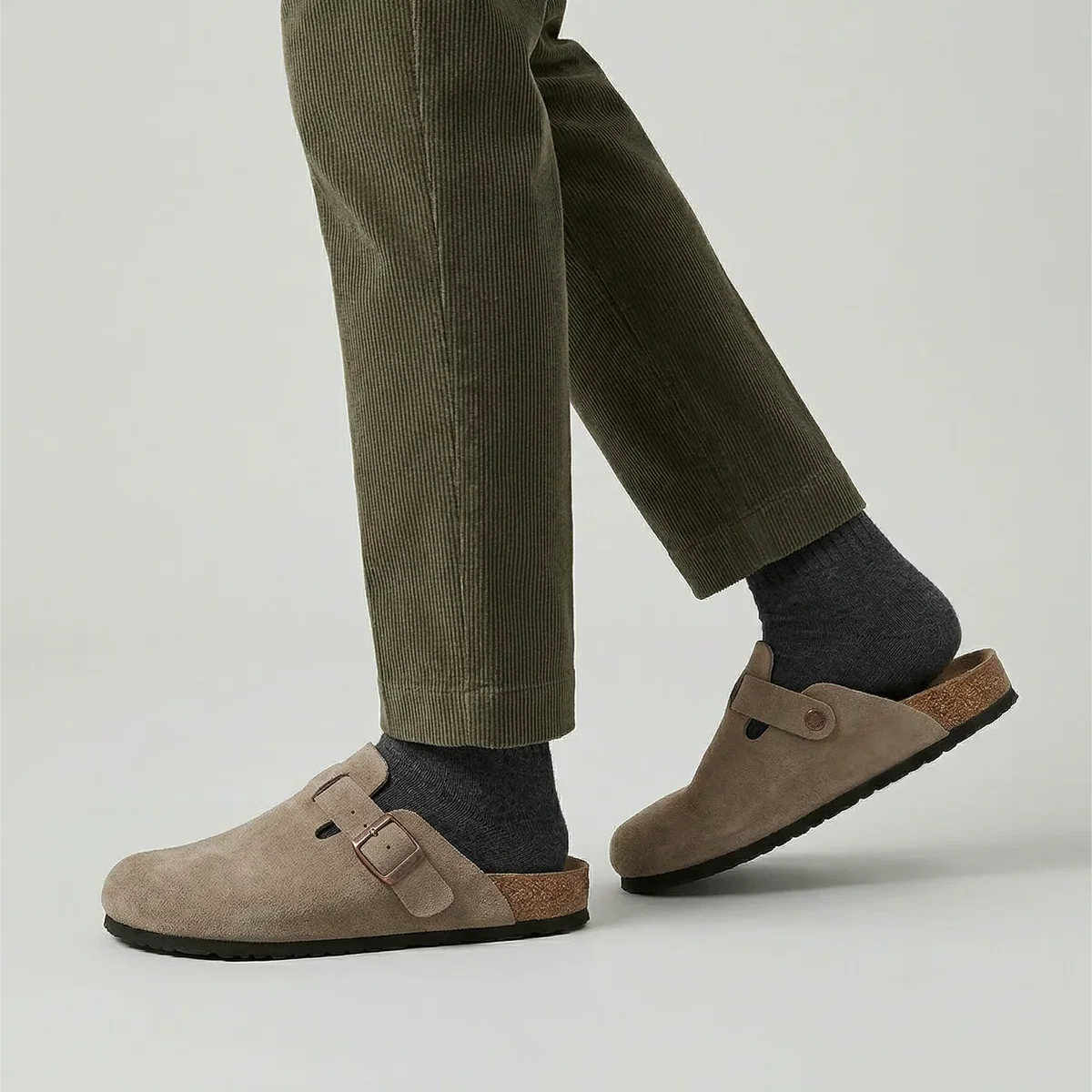 Men's beige suede clogs showing closed-toe design with textured outsole and buckle fastening
