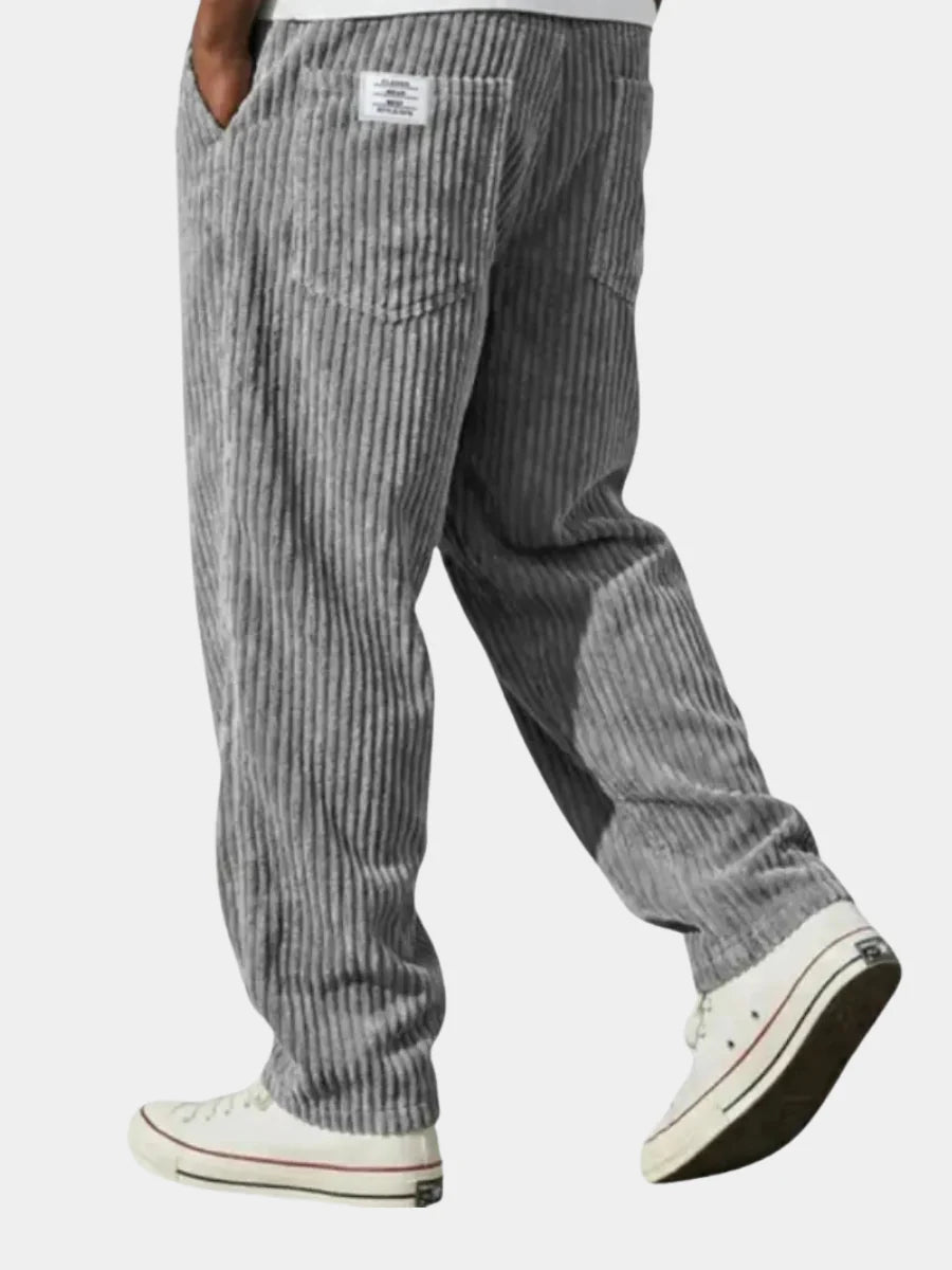 Men's grey corduroy trousers with relaxed fit and ribbed texture, featuring elasticated drawstring waist and side pockets